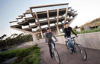Two bicyclists riding on campus near Geisel Library