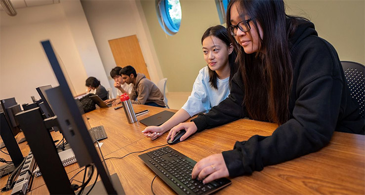 Two students in UC San Diego computer science course CSE 8 use the AI tutor prototype outside of class to study and do homework. Photo: David Baillot/UC San Diego Jacobs School of Engineering