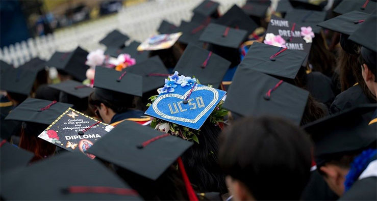 Graduating students at UCSD with their decorated commencement caps
