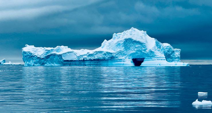 Blue-tinted ice shelf floats in the Antarctic Ocean