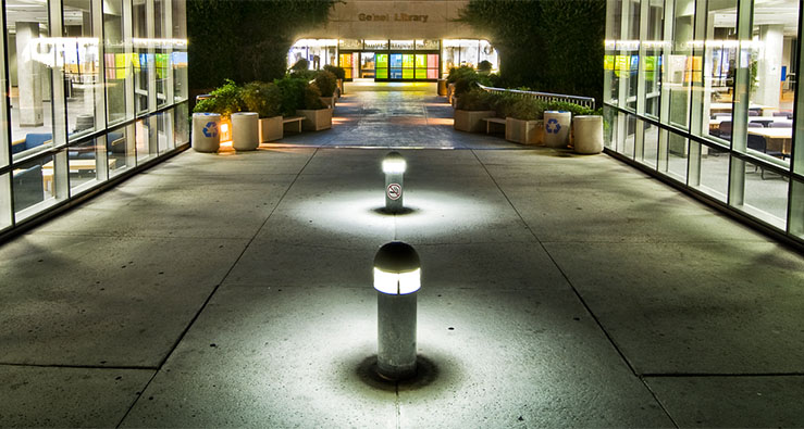 UCSD's Geisel Library, lit up at night, with the Dr. Seuss statue in the foreground