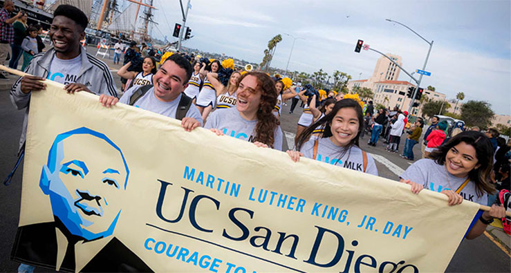 UC San Diego students carry a banner at the head of the annual MLK Jr Day parade along the San Diego harbor