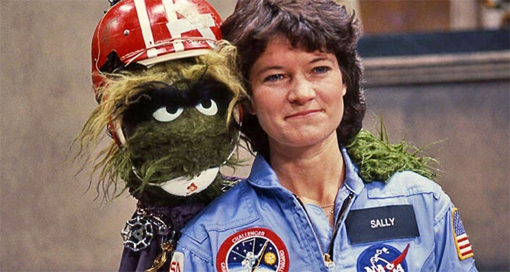 Astronaut Sally Ride poses in her NASA uniform with Sesame Street character Grundgetta