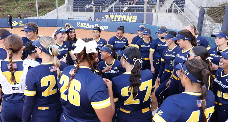 Triton softball team in blue uniforms gather around home plate