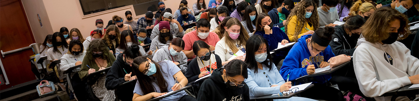 UC San Diego lecture hall filled with students at work (students wearing facial masks)