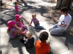 Grad-student mother gives a friendly finger puppet show on campus during a student-parent advocacy event. 